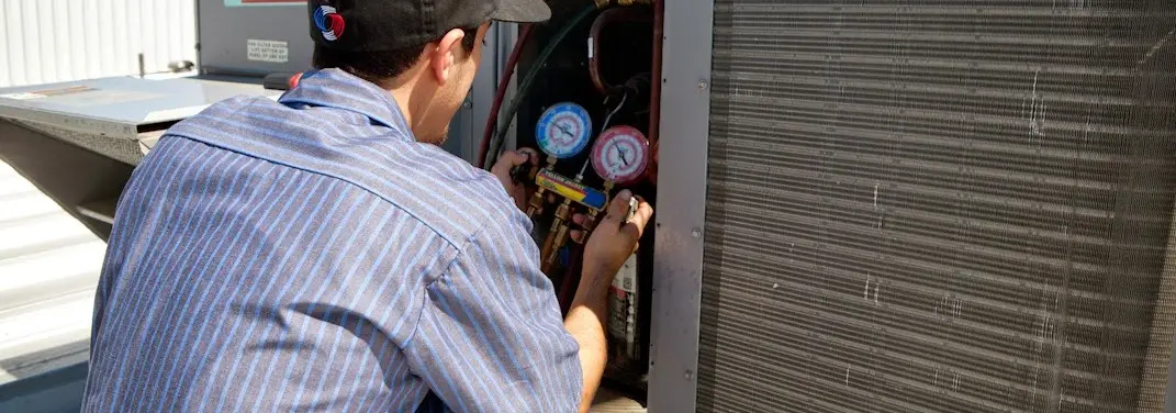 HVAC technician servicing a condenser unit in Boonton