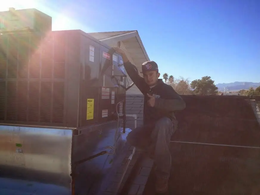 HVAC technician performing Air Duct Repair on a rooftop unit in Boonton